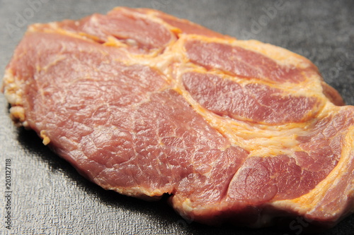 Raw pork meat on a dark gray