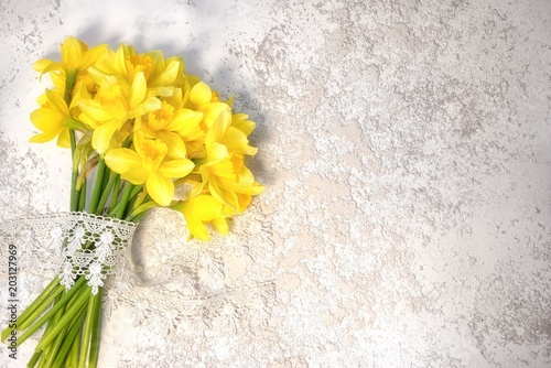 Fototapeta Naklejka Na Ścianę i Meble -  narcissus bouguet with lace laying on the silver grey cement background with copy space