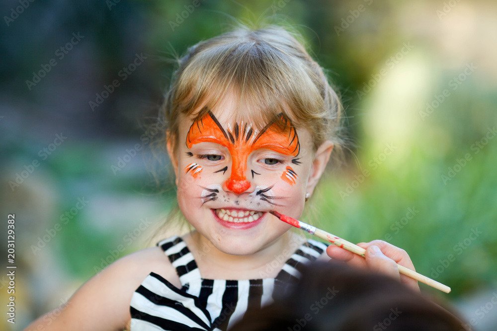 Fototapeta premium Adorable girl getting her face painted