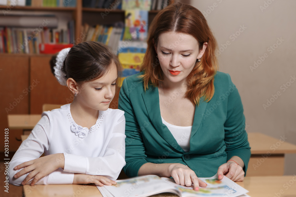 Happy Young Mother Helping Her Daughter While Studying At Home Happy Young Mother Helping Her Daughter While Studying At Home