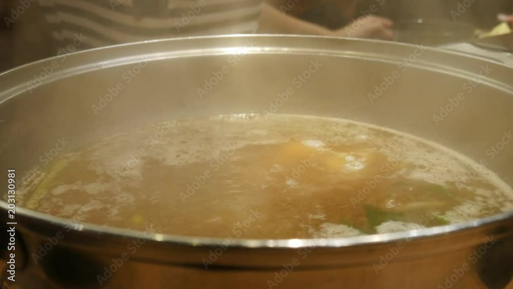 People eating suki yaki or shabu shabu in hot pot with smoke. Close up at a pot. People eating suki yaki or shabu shabu in hot pot with smoke. Close up at a pot.
