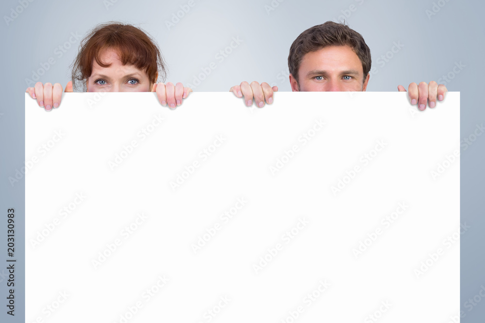 Couple looking at the camera against grey vignette Couple looking at the camera against grey vignette