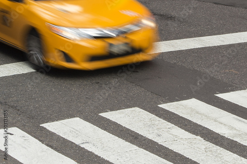 Yellow Taxi Cabin in motion on the pedestrian strips in Times Square, New York City, USA.