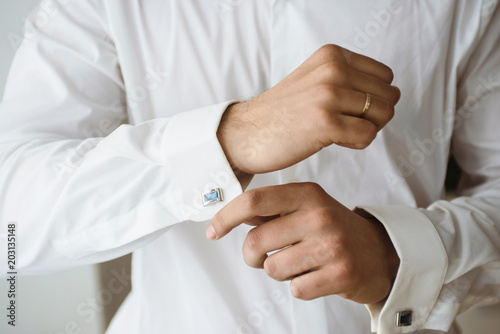 Close up of businessman wearing cufflinks. Elegant young fashion business man wearing suit