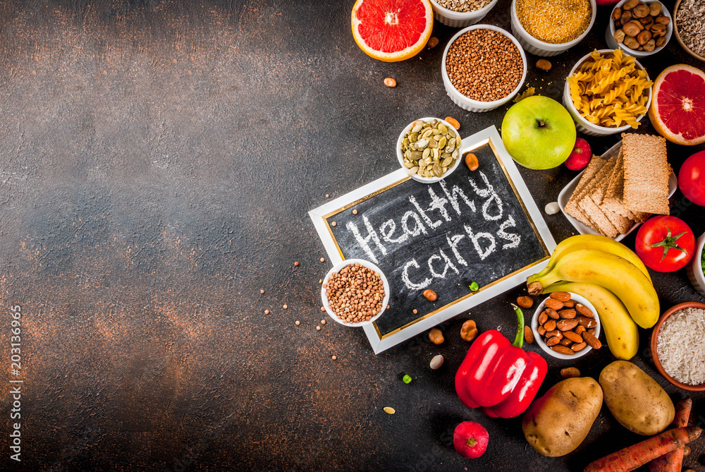 Diet food background concept, healthy carbohydrates (carbs) products - fruits, vegetables, cereals, nuts, beans, dark blue concrete background top view copy space