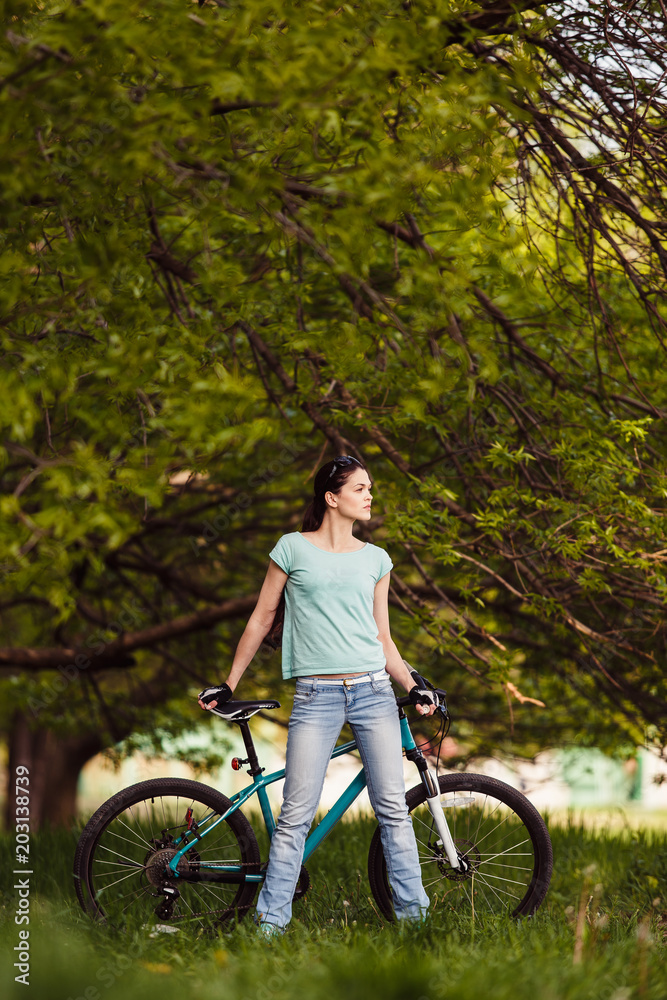 Young woman with bicycle on nature