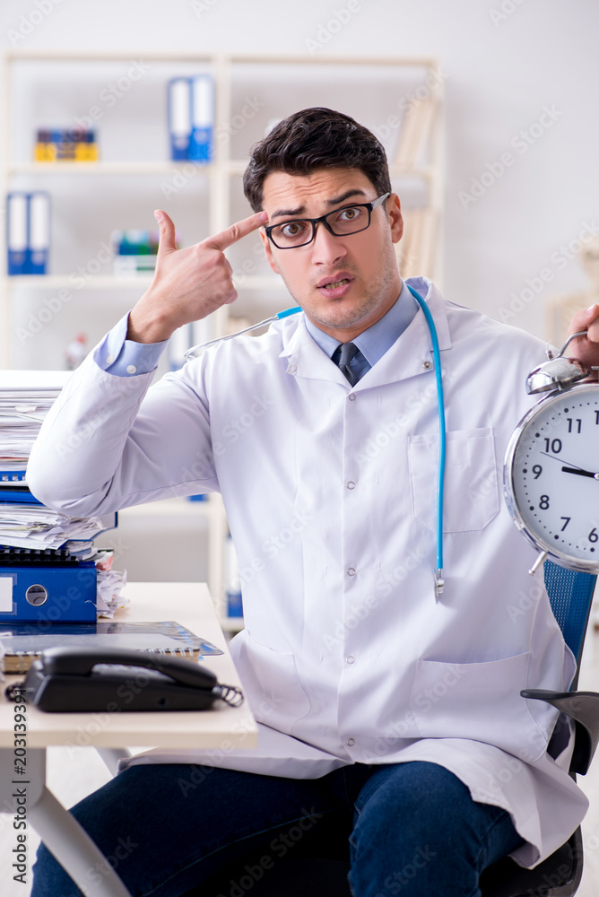 Doctor with alarm clock in urgent check-up concept Doctor with alarm clock in urgent check-up concept