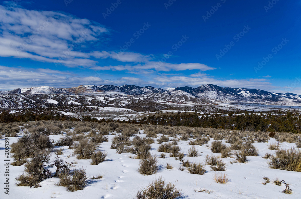 Snow capped mountain in Montana with blue sky and clouds.