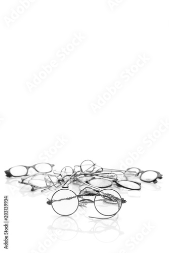 Vintage broken eyeglasses isolated on white background. Vertical format with copy space for text, black and white effect
