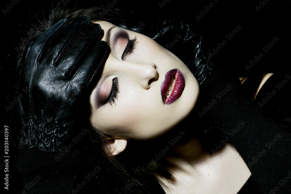 Fashion model hold face with black leather gloves. Sensual woman with makeup face. Woman with long brunette hair. Beauty girl with glamour look. Beauty fashion and look concept Stock Adobe