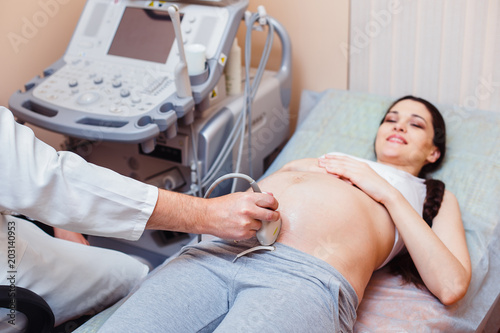 Professional doctor screening of pregnant woman by ultrasound.