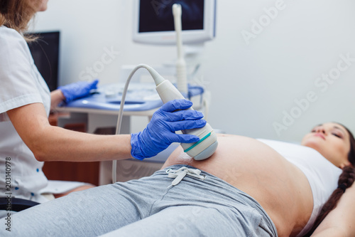 Professional doctor screening of pregnant woman by ultrasound.