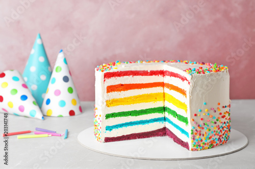 Delicious rainbow cake for party on table