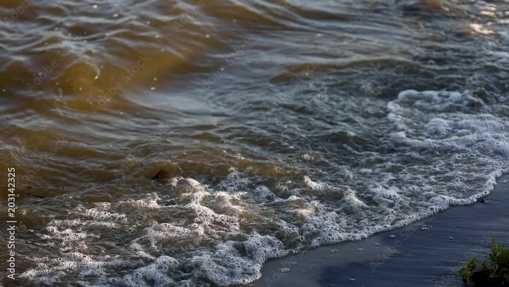 Waves roll onto a sandy beach during sunset Waves roll onto a sandy beach during sunset