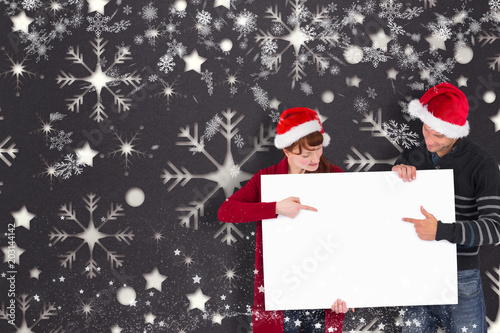 Couple holding a white sign against snowflake wallpaper pattern © vectorfusionart