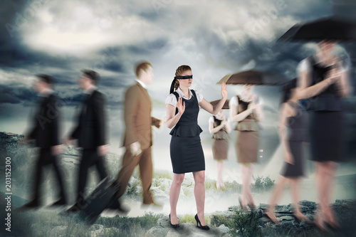Redhead businesswoman in a blindfold against stormy sky with tornado over landscape