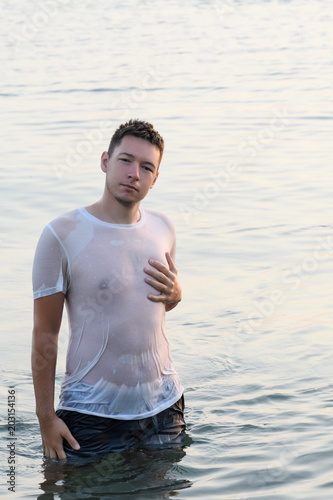 A man standing waist-deep in water seductive put my hand on his chest