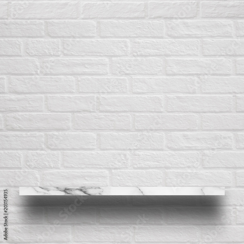 Empty top of white marble shelf with brick wall.