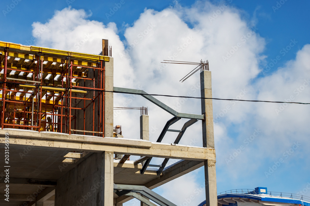 Monolithic construction of multi-storey Parking of concrete on the background of clouds and blue sky. Installation of formwork for concrete floors. Monolithic construction of multi-storey Parking of concrete on the background of clouds and blue sky. Installation of formwork for concrete floors.