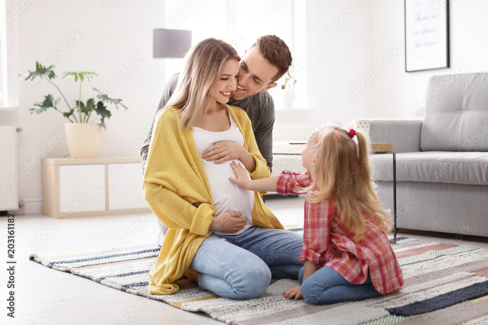 Young pregnant woman with her family at home - obrazy, fototapety, plakaty 