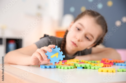 Vászonkép Little girl with autistic disorder playing at home, closeup of puzzles