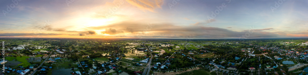 Panorama Top view Aerial photo from flying drone over village in Thailand.Top view beautiful Sunset.Sunrise with cloud over rice field.