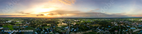 Panorama Top view Aerial photo from flying drone over village in Thailand.Top view beautiful Sunset.Sunrise with cloud over rice field.