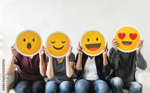 Diverse people holding emoticon photo