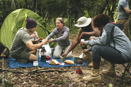 Group of diverse friends camping in the forest