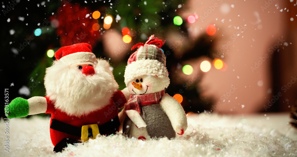Snow falling against santa claus and snowman on snow Snow falling against santa claus and snowman on snow