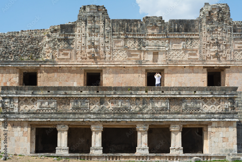 Un turista toma fotos de las estructuras de las Pirámides de Uxmal Mérida Yucatán.