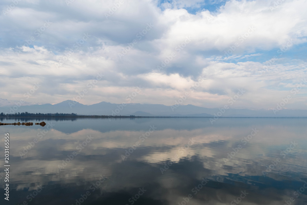 Symmetrical cloudy sky reflection in the water surface of Convento Viejo Dam in Chile, VI region near Chimbarongo and San Fernando