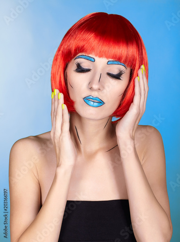 Female in red wig and in comic pop art make-up style on blue background
