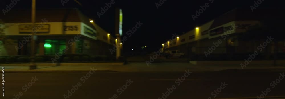 Left Side view of a Driving Plate: Car travels on East Colorado Boulevard in Pasadena, California at night, crossing Craig Avenue, pausing near Sierra Madre Boulevard, and continuing on to make a left turn at Sunnyslope Avenue into a parking lot.