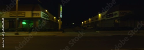 Left Side view of a Driving Plate: Car travels on East Colorado Boulevard in Pasadena, California at night, crossing Craig Avenue, pausing near Sierra Madre Boulevard, and continuing on to make a left turn at Sunnyslope Avenue into a parking lot.