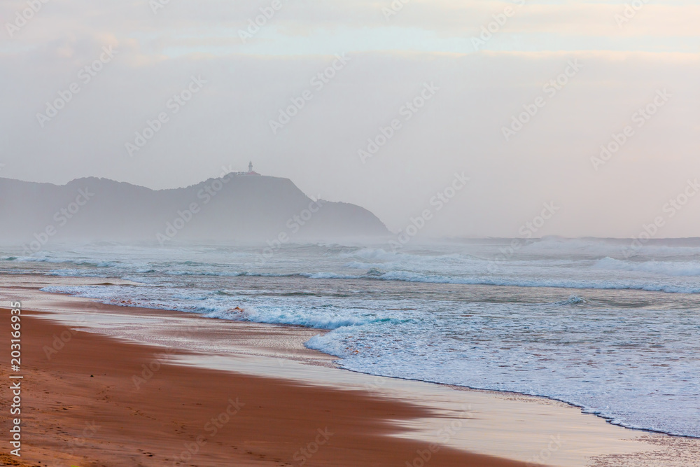 Byron Bay Lighthouse on a cliff disappearing in the morning mist. Byron Bay, New South Wales, Australia Byron Bay Lighthouse on a cliff disappearing in the morning mist. Byron Bay, New South Wales, Australia