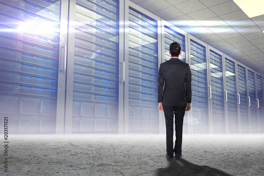 Businessman turning his back to camera against server hallway in a desert Businessman turning his back to camera against server hallway in a desert