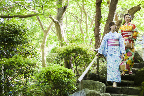 浴衣を着ている女性たちは日本庭園を散策している