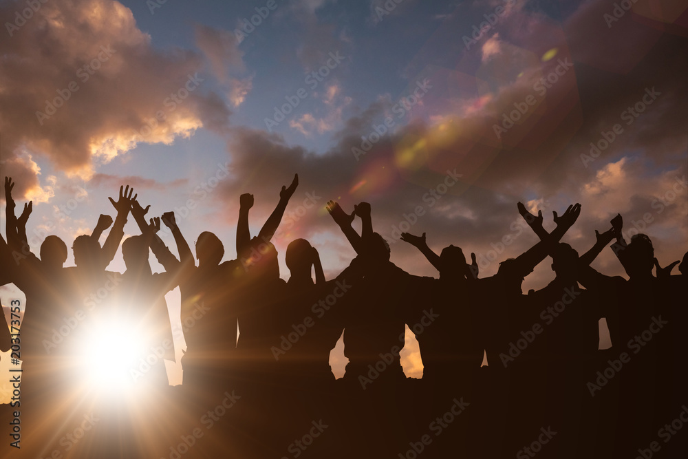 Fototapeta premium Silhouetters celebrating against clouds