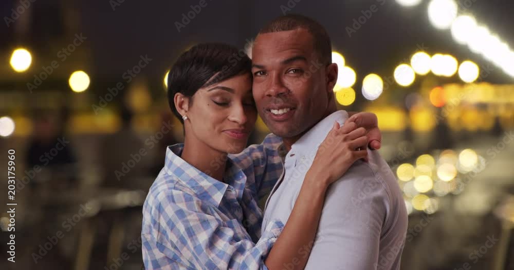 Young African couple in love embracing each other outside on a Romantic night out, Loving young Black male and female looking intimately at the camera together, 4k Young African couple in love embracing each other outside on a Romantic night out, Loving young Black male and female looking intimately at the camera together, 4k