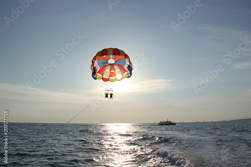 A man and a girl are flying on a parachute.