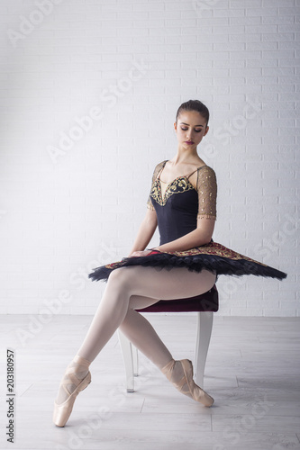 Yooung ballerina sitting on the chair and concentrate for performans photo