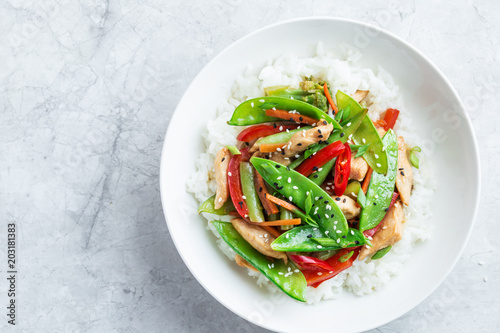 Foto stir fry chicken and vegetables with rice in white bowl