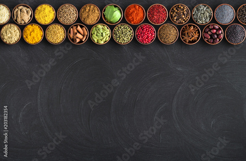 Indian spices on black table background. chalkboard for food with condiments