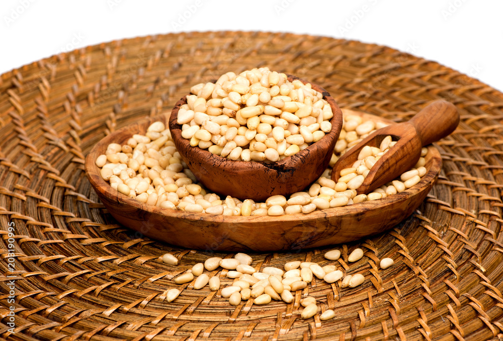 Cedar pine nuts in a bowl and a wooden scoop