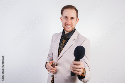 Young man with microphone on white background, leading with microphone