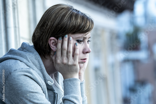 young attractive unhappy woman with depression and anxiety feeling miserable and hopeless on home balcony photo