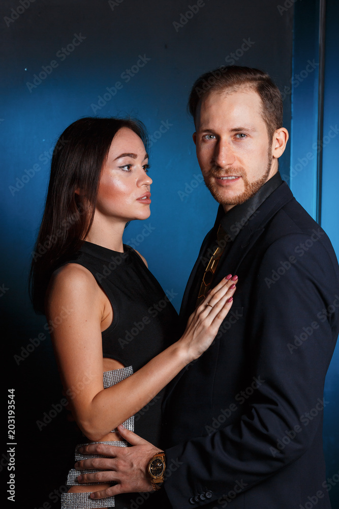 guy and girl in love posing on a black background