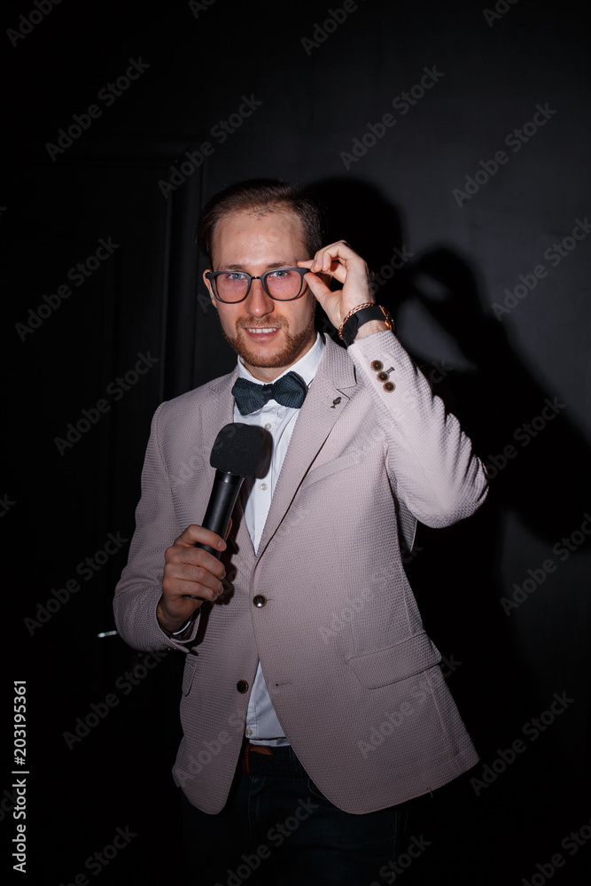 Naklejka premium Young man with microphone on white background, leading with microphone