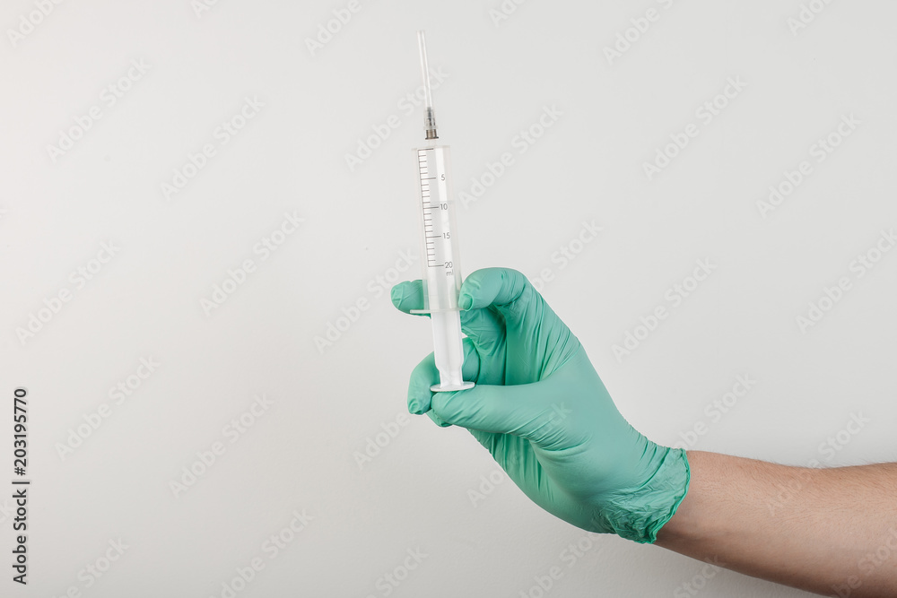 Hand in medical glove with syringe on white background Hand in medical glove with syringe on white background